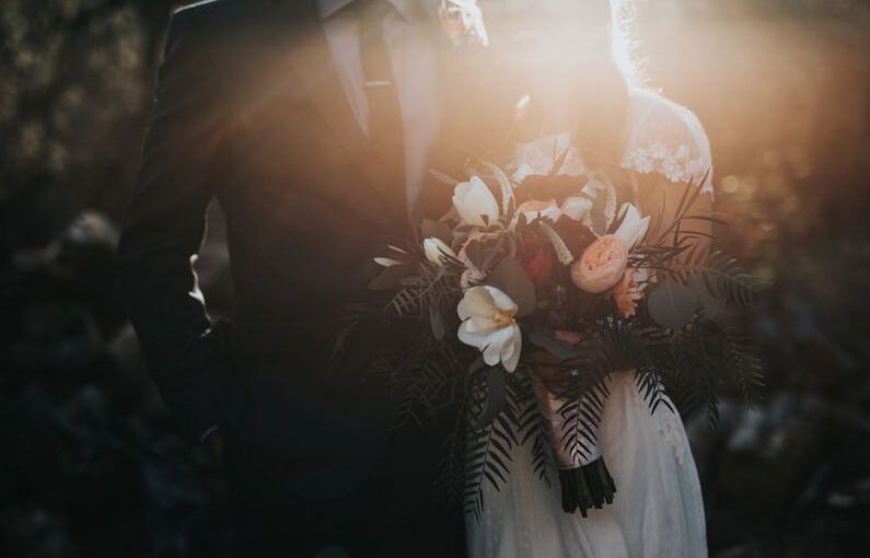 Wedding Savings - groom beside bride holding bouquet flowers