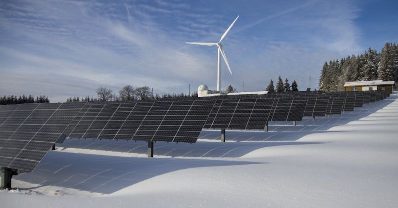 Solar Tech - Solar Panels on Snow With Windmill Under Clear Day Sky