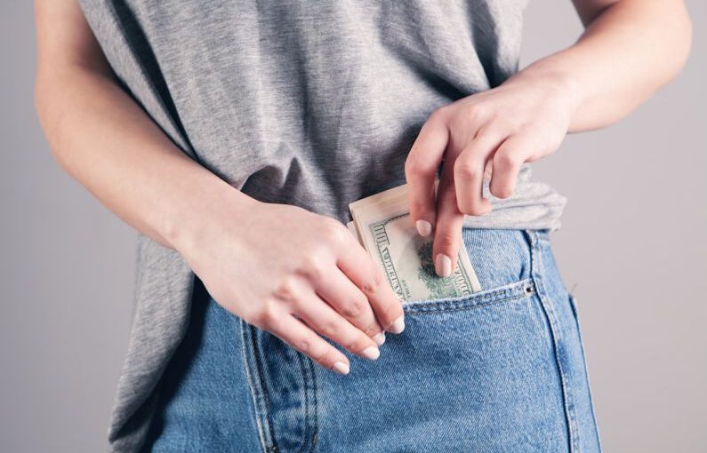 Fashion Savings - person in gray shirt and blue denim jeans holding blue denim jeans